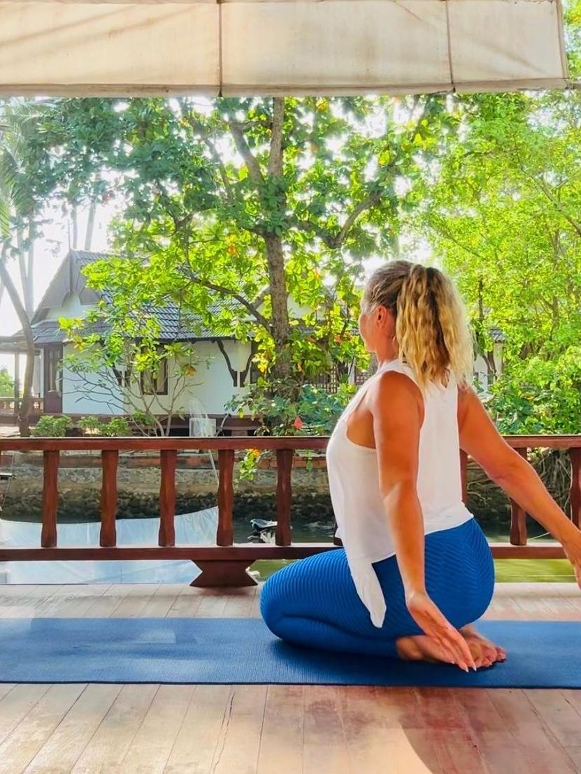 Seated yoga practice on a riverside deck