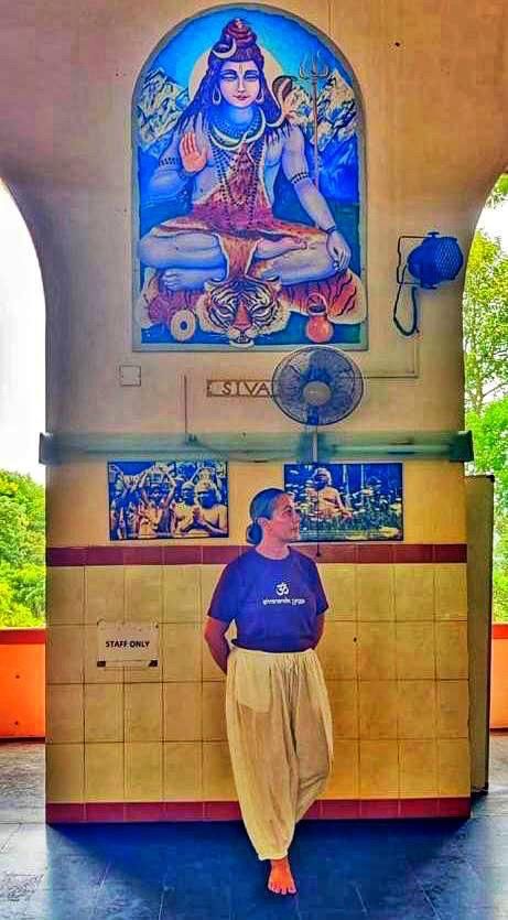 Carly at the Sivananda ashram, beneath a mural of Shiva