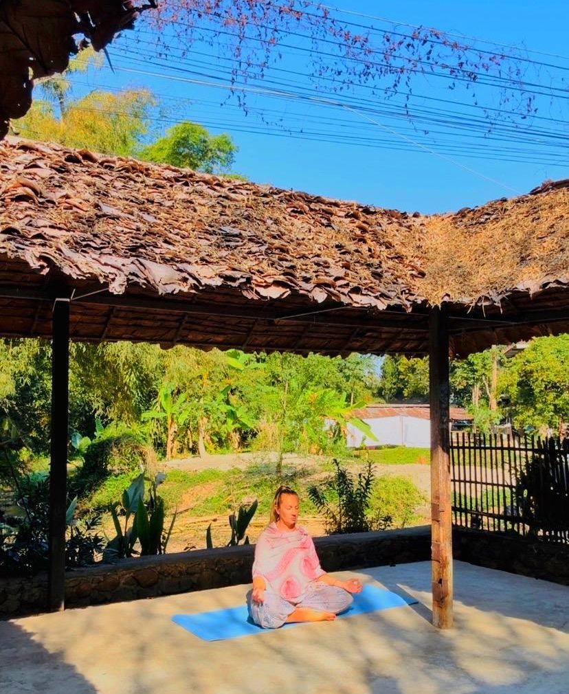 Seated meditation under a thatched shelter